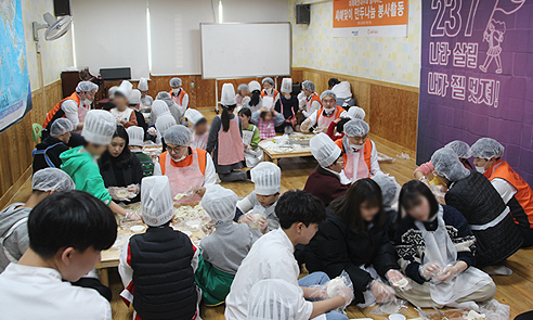 당일 사회공헌활동에 대한 설명을 듣고 아이들과 함께 만두를 빚는 신입사원들 사진